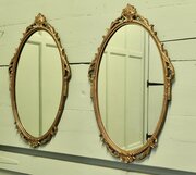 A Pair Of Decorative Oval Gilt Wall Mirrors