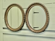 A Pair Of Simulated Wood Finish Oval Mirrors