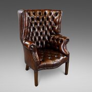A Deep Buttoned Chestnut Brown Barrel Back Wing Chair