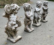 A Set of 4 Weather Worn Cherub Statues with Instru